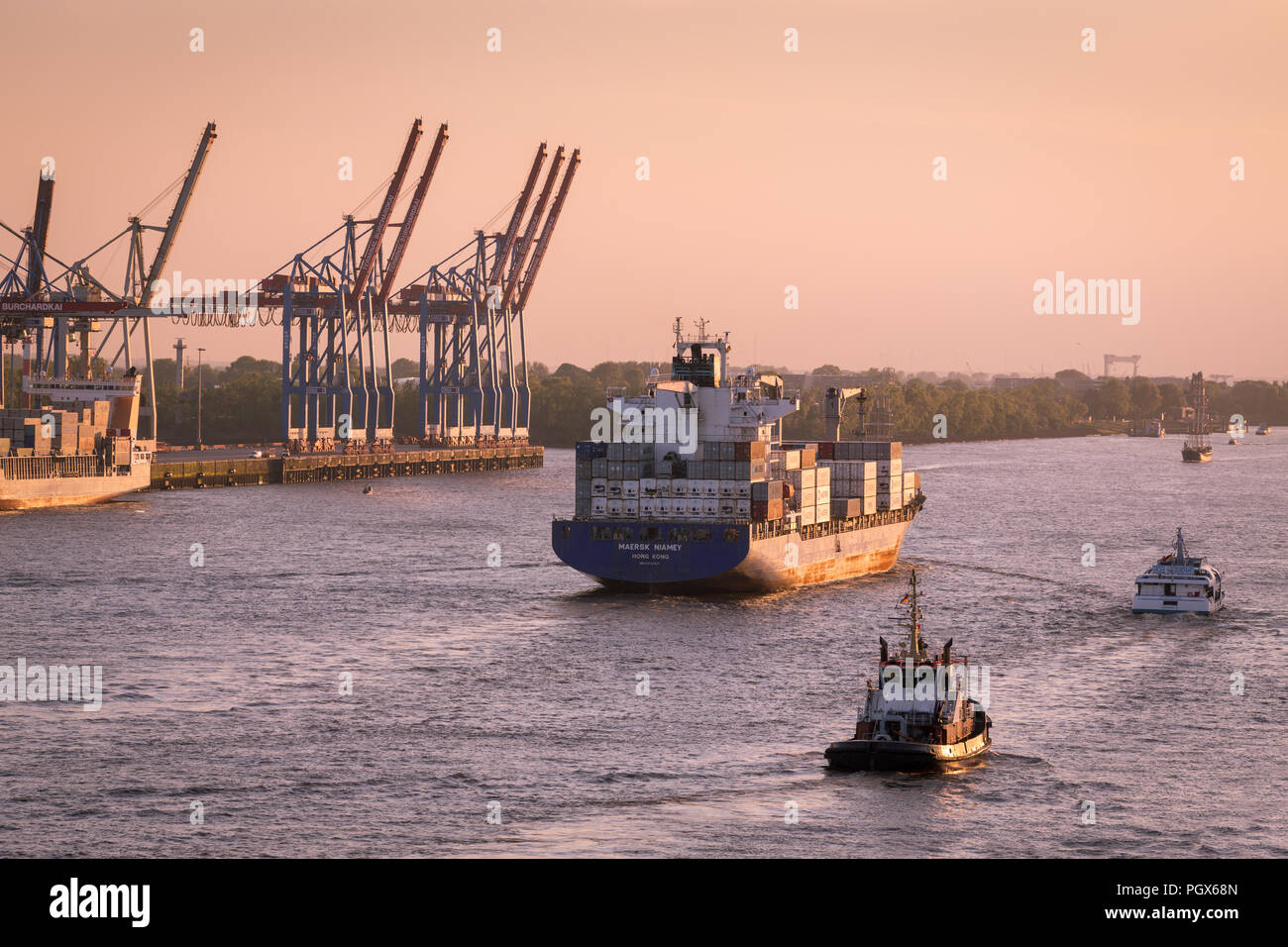 Contenitore Freighter, Cargo nave lascia il porto di Amburgo sul fiume Elba al tramonto, Amburgo, Germania Foto Stock