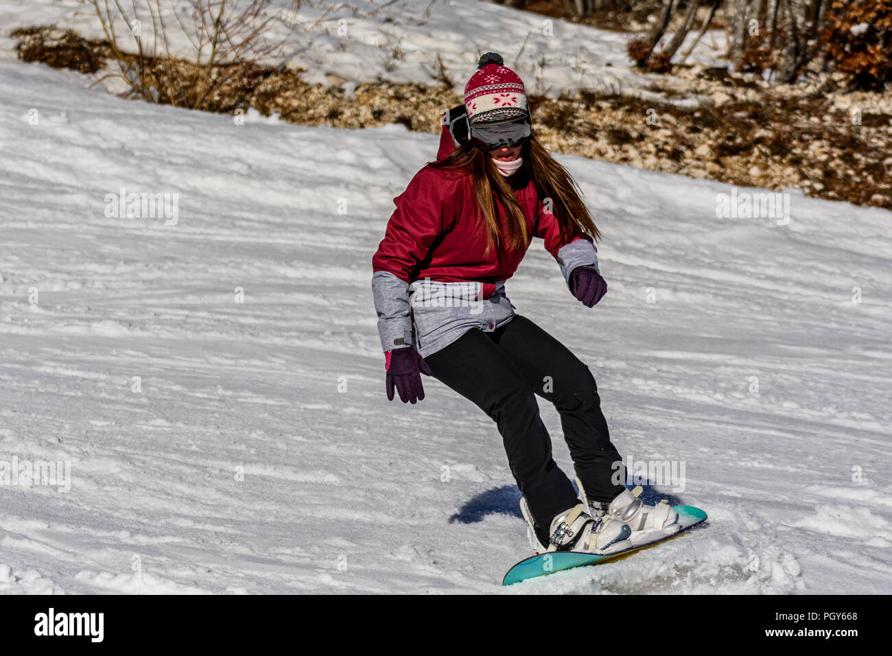 Una femmina di snowboarder in azione Foto Stock