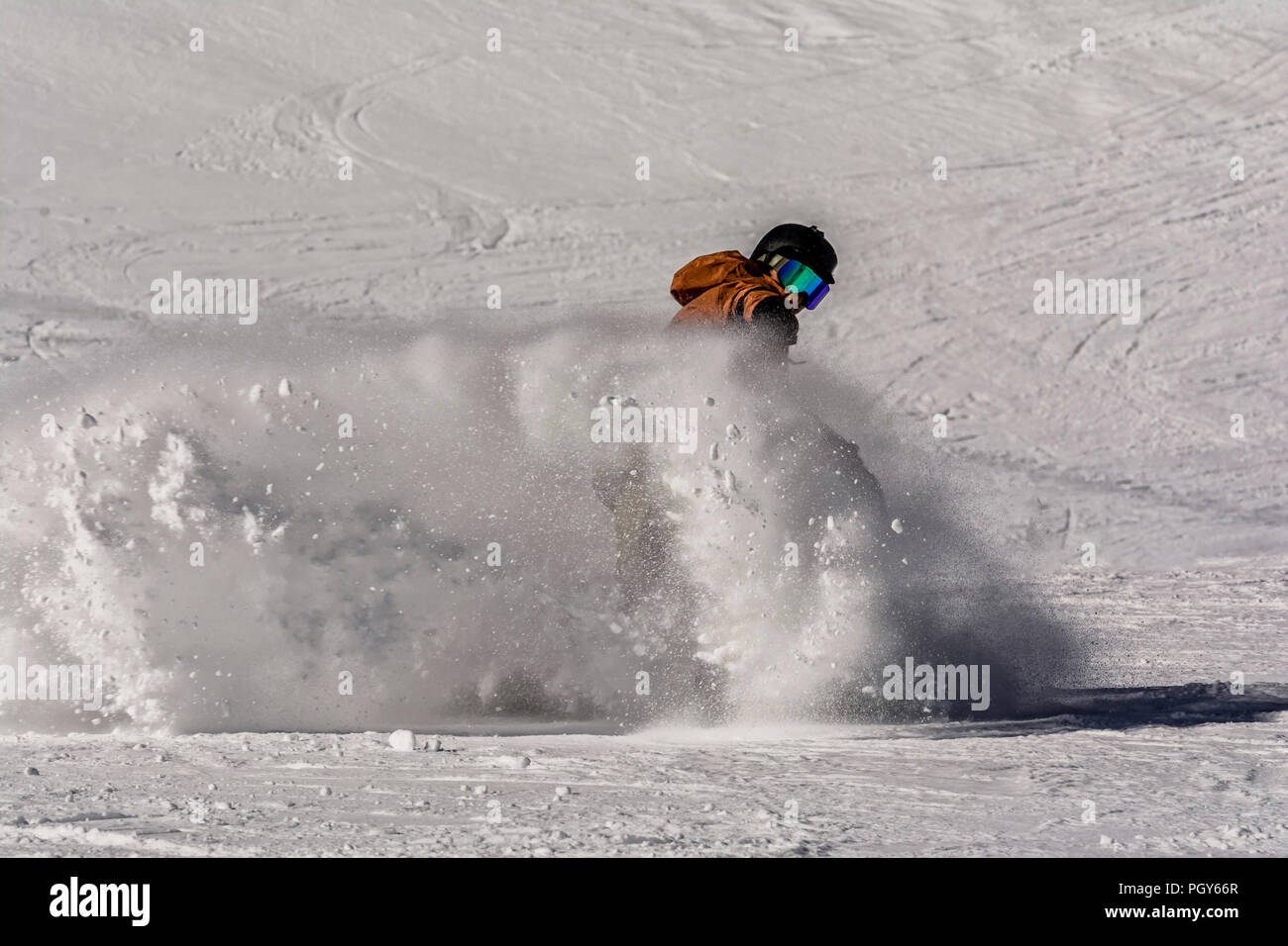 Un freestyle snowboarder freni e creare un onda di neve in polvere Foto Stock