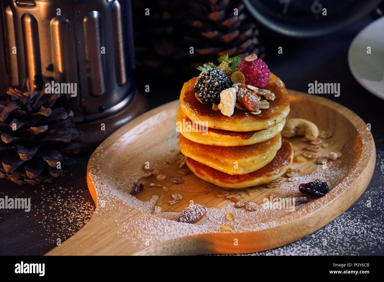 Pancake con frutti di bosco e il dado e cereali e sulla piastra di legno. Foto Stock
