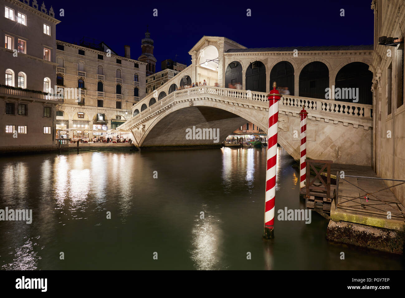Il Ponte di Rialto e il Canal Grande con la gente e i turisti di notte a Venezia, Italia Foto Stock
