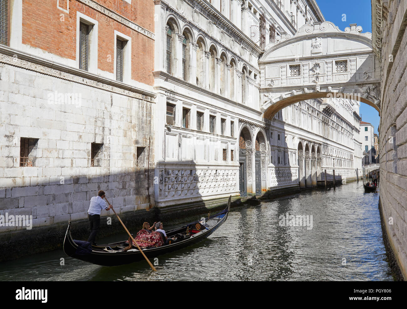 Ponte dei Sospiri, donna fotografare e uomo sulla gondola barca guardando il famoso ponte in una soleggiata giornata estiva a Venezia, Italia Foto Stock