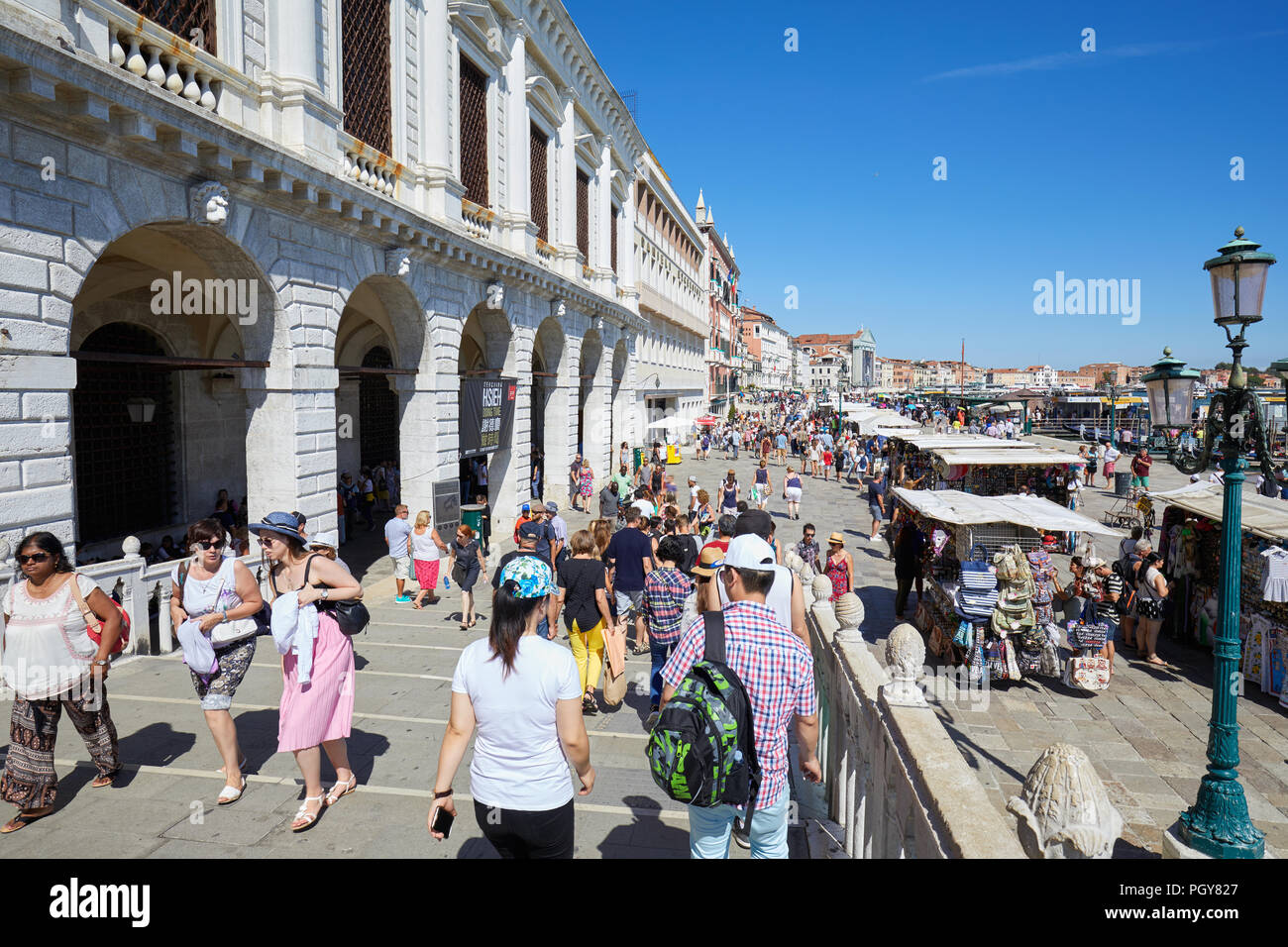 Cittadini e turisti sul ponte e dock a Venezia vicino a piazza San Marco in una soleggiata giornata estiva in Italia Foto Stock