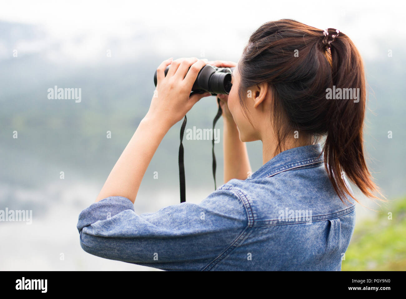 Avventura tailandese ragazza felice guardando con il binocolo sulla riva del lago di Como Foto Stock