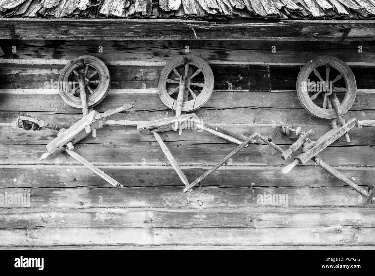 Vintage tradizionale in legno ruote di filatura sulla parete di legno del maneggio. Foto Stock