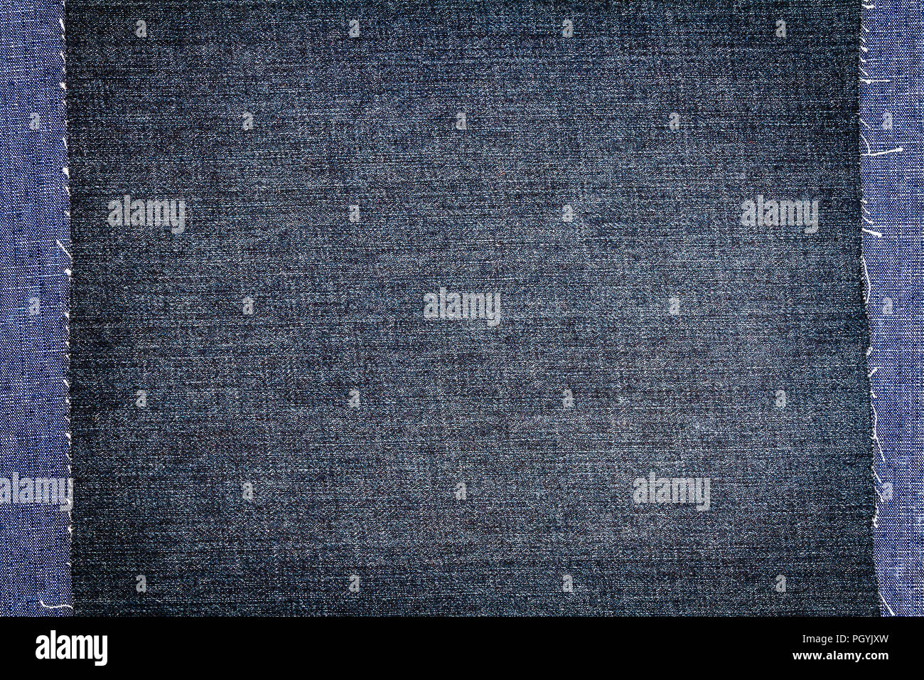 Due pezzi di tessuto jeans uno sull'altro. Ruvida bordi irregolari. Jeans Denim strappato Foto Stock
