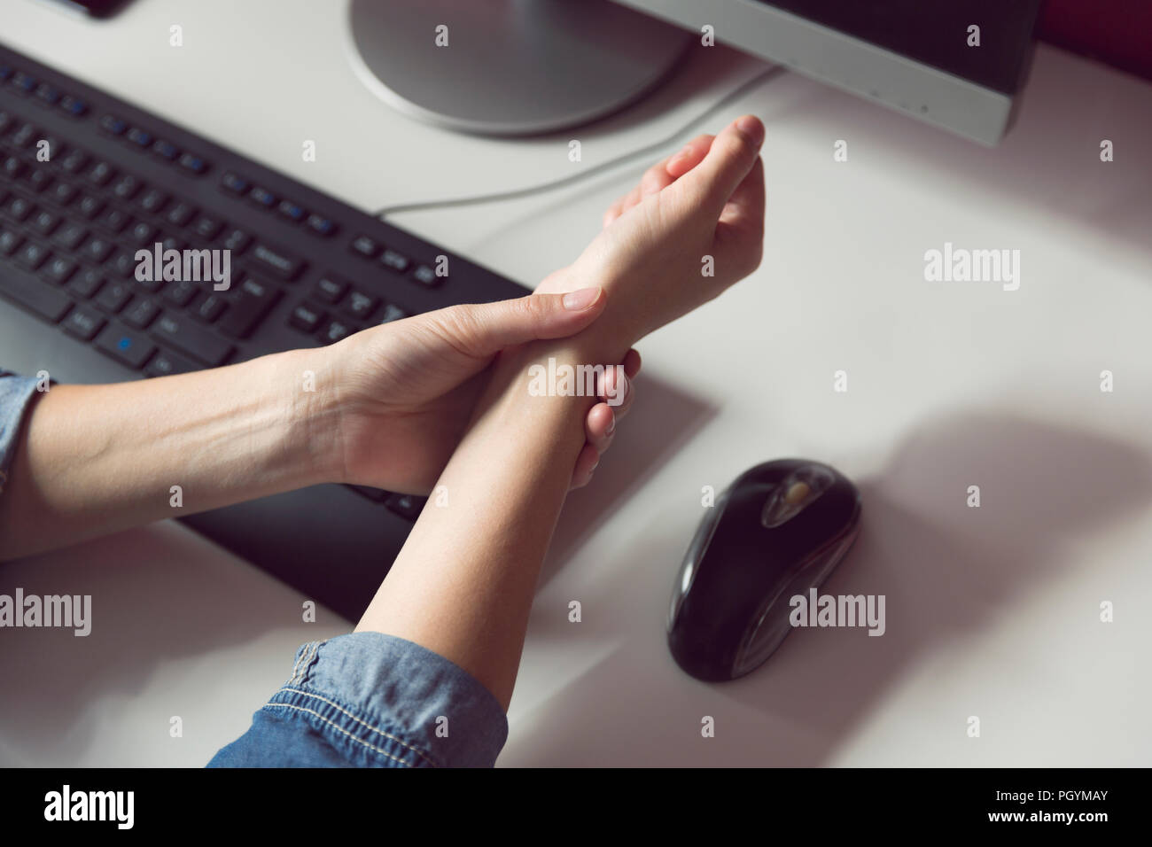 La sindrome di Office - Giovani donne che soffrono di dolori a mano mentre si utilizza il computer al lavoro. Professionali di fattore di rischio. Medico e sanitario concetto. Foto Stock