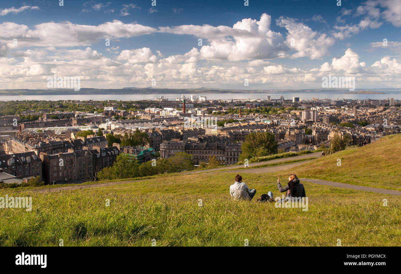 Edimburgo, Scozia, Regno Unito - 30 Maggio 2011: persone sedersi in un parco su Calton Hill godendo una giornata di sole in Edimburgo, con il sobborgo di Leith e Firth of F Foto Stock