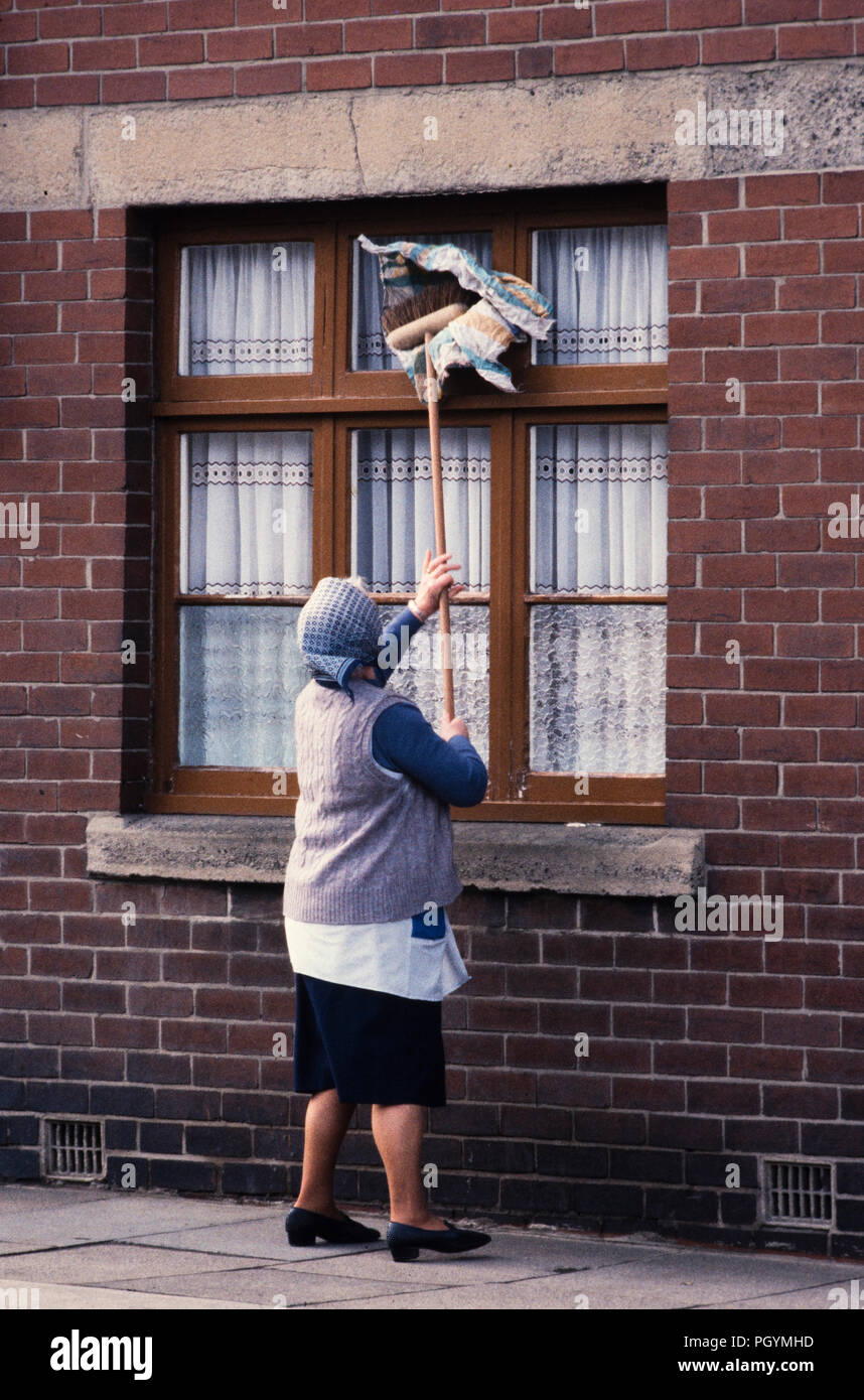 Easington Colliery Contea di Durham in Inghilterra. Donna pulizia di Windows. 1985 Foto Stock