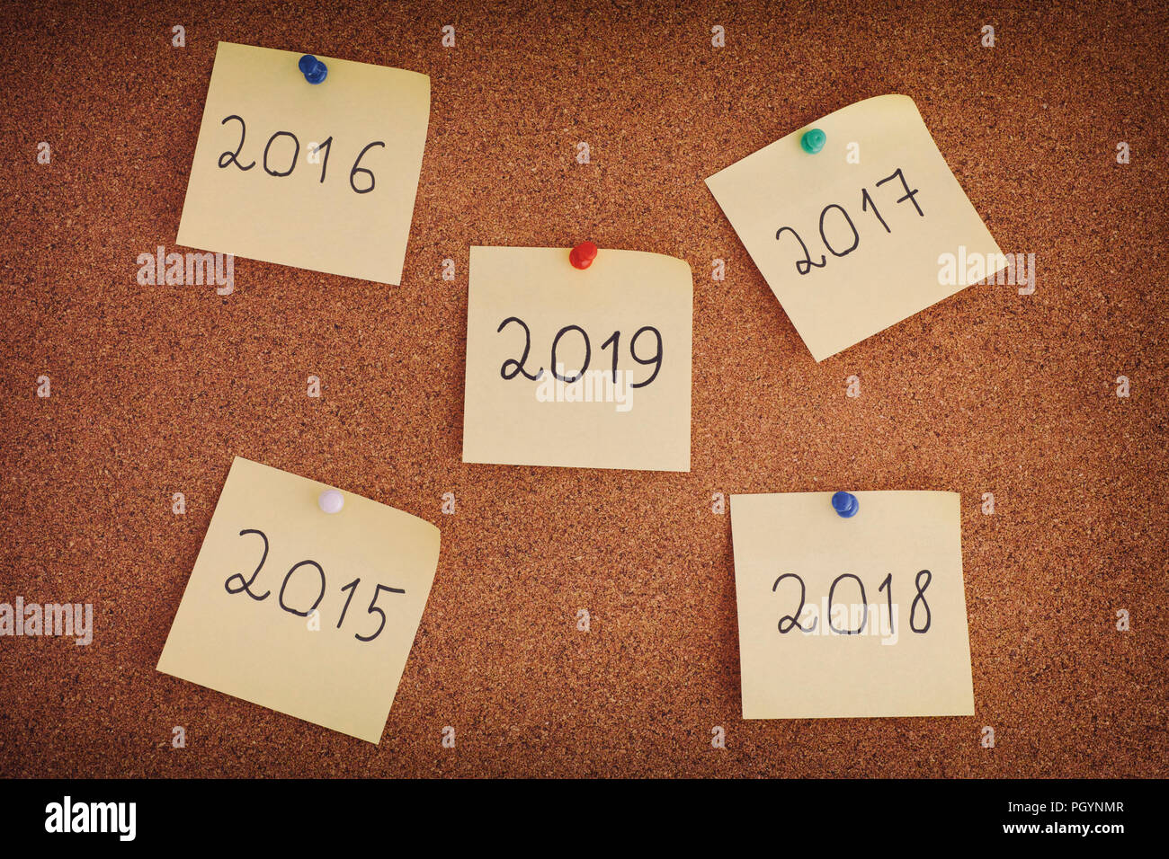 Post-it con anni dal 2015 al 2019 su una bacheca. Primo piano. Foto Stock