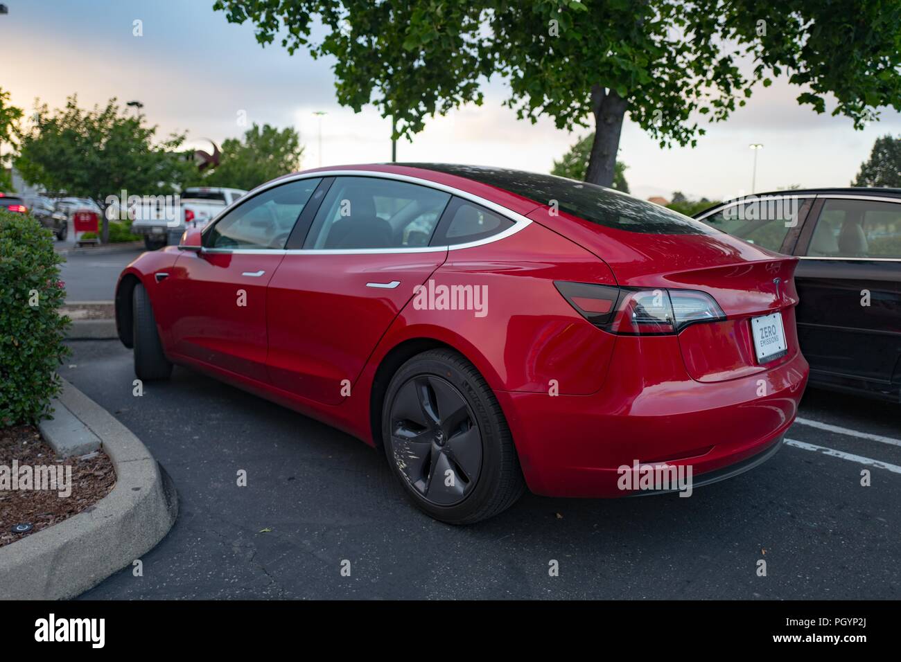 Vista laterale di un rosso modello Tesla 3 auto elettrica da Tesla Motors sotto un cielo drammatico nell'Area della Baia di San Francisco, Dublino, California, 21 maggio 2018. () Foto Stock