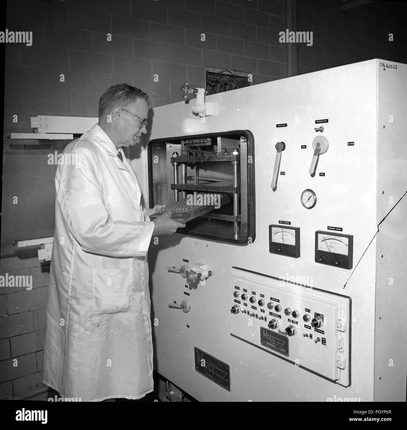 Fotografia in bianco e nero del tecnico di laboratorio Bonnie Smith, che indossa un mantello bianco e il caricamento di uno scafo liofilizzatore, un liofilizzatore che prolunga la durata di vita di materiali deperibili in modo che essi possono essere spediti e immagazzinati senza la necessità di refrigerazione, Immagine cortesia CDC/Dr Andrew Fodor, 1967. () Foto Stock