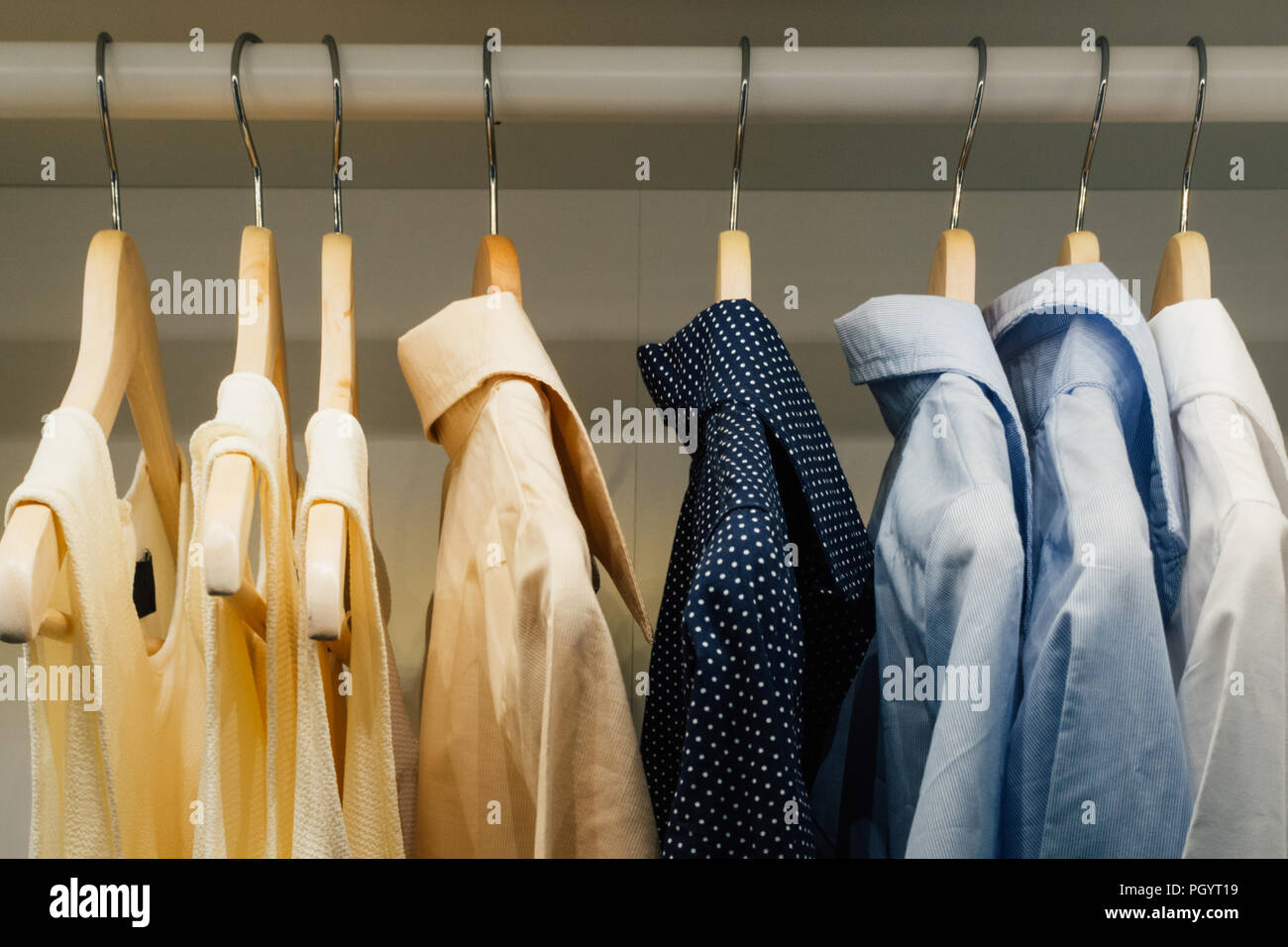 Abbigliamento uomo camicia e abito femminile appesa al guardaroba nella famiglia spogliatoio a casa. film di stile foto. Foto Stock