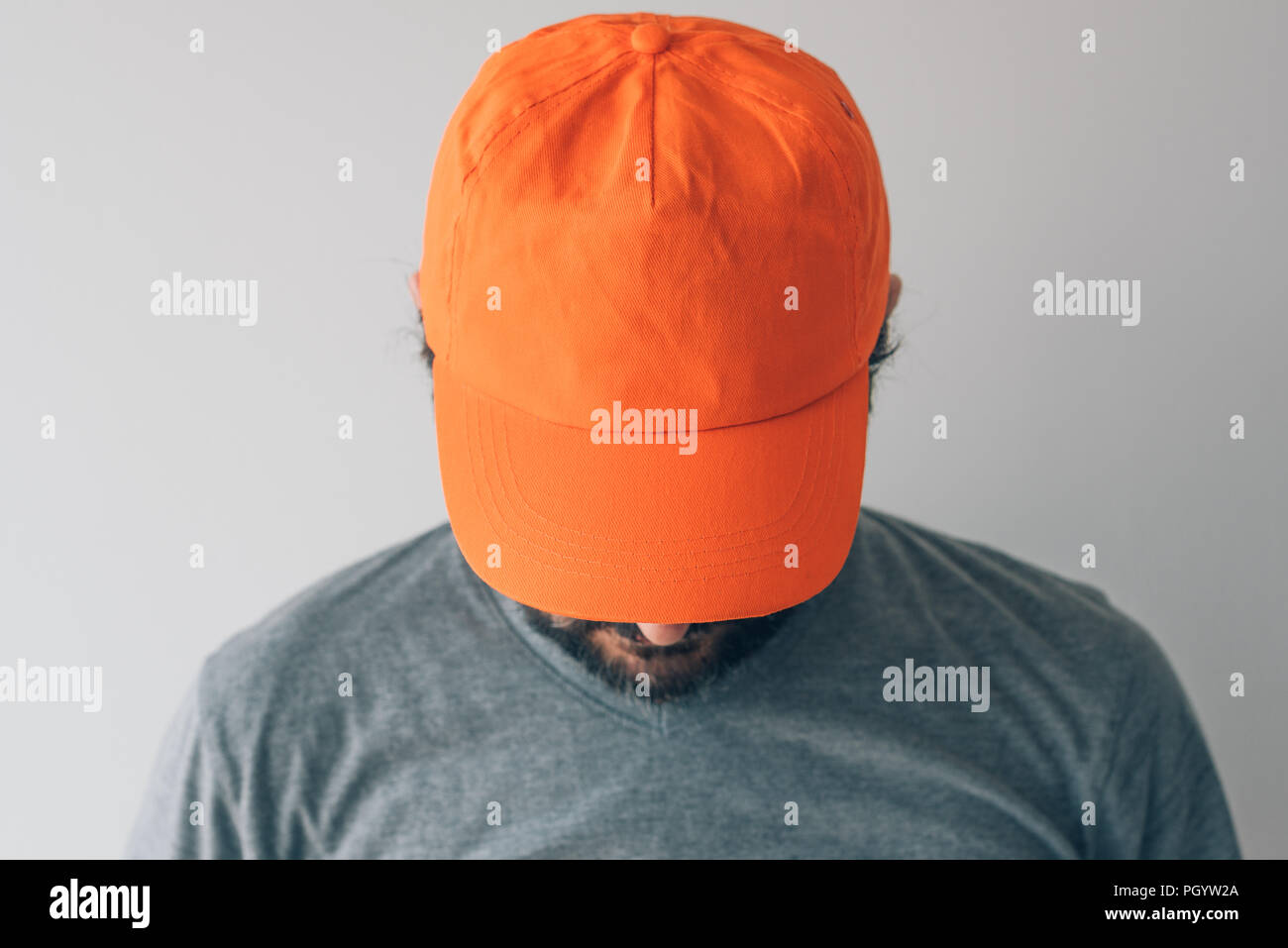 Uomo che indossa orange cappello da baseball per mockup testo o grafica design Foto Stock