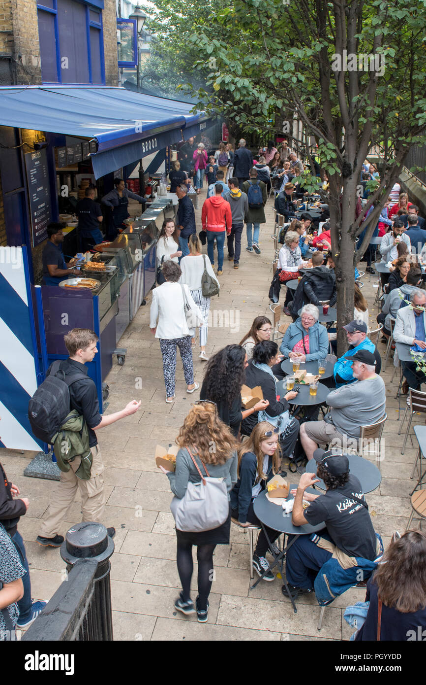 La folla al mercato di Borough nel centro di Londra a pranzo. street foods in vendita su un mercato alimentare. Foto Stock