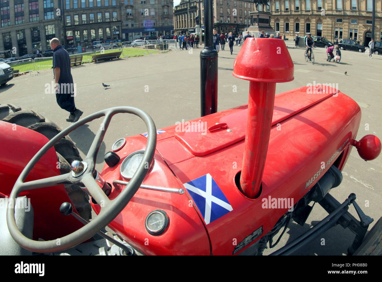 Glasgow, Scotland, Regno Unito. 29 Agosto, 2018. Ora di pranzo gli ospiti sono stati trattati per un po' di storia vivente come un classico rosso 1964 Massey Ferguson 35X trattore è apparso nella città del George Square. La gente del posto e i turisti hanno guardato come il tappeto erboso che è stato sollevato per il recente Campionato Europeo accogliente centro è stato sostituito. Il modello Sport insoliti ruote doppie per aumentare la trazione e è stata modificata dal proprietario fiero nella foto. Gerard Ferry/Alamy news Foto Stock