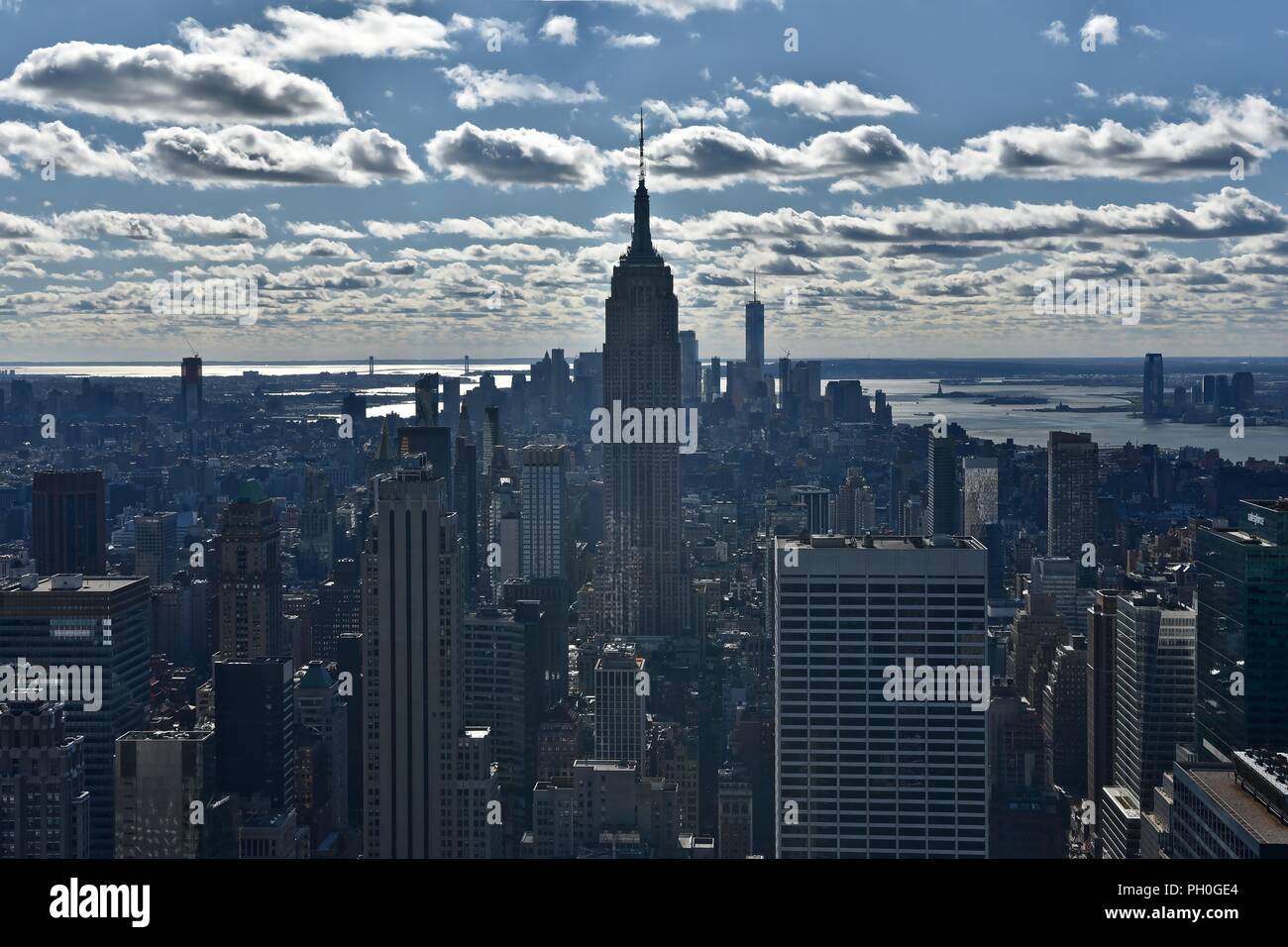 New York paesaggio urbano riprese contro il sole luminoso con Empire State building che domina la vista Foto Stock