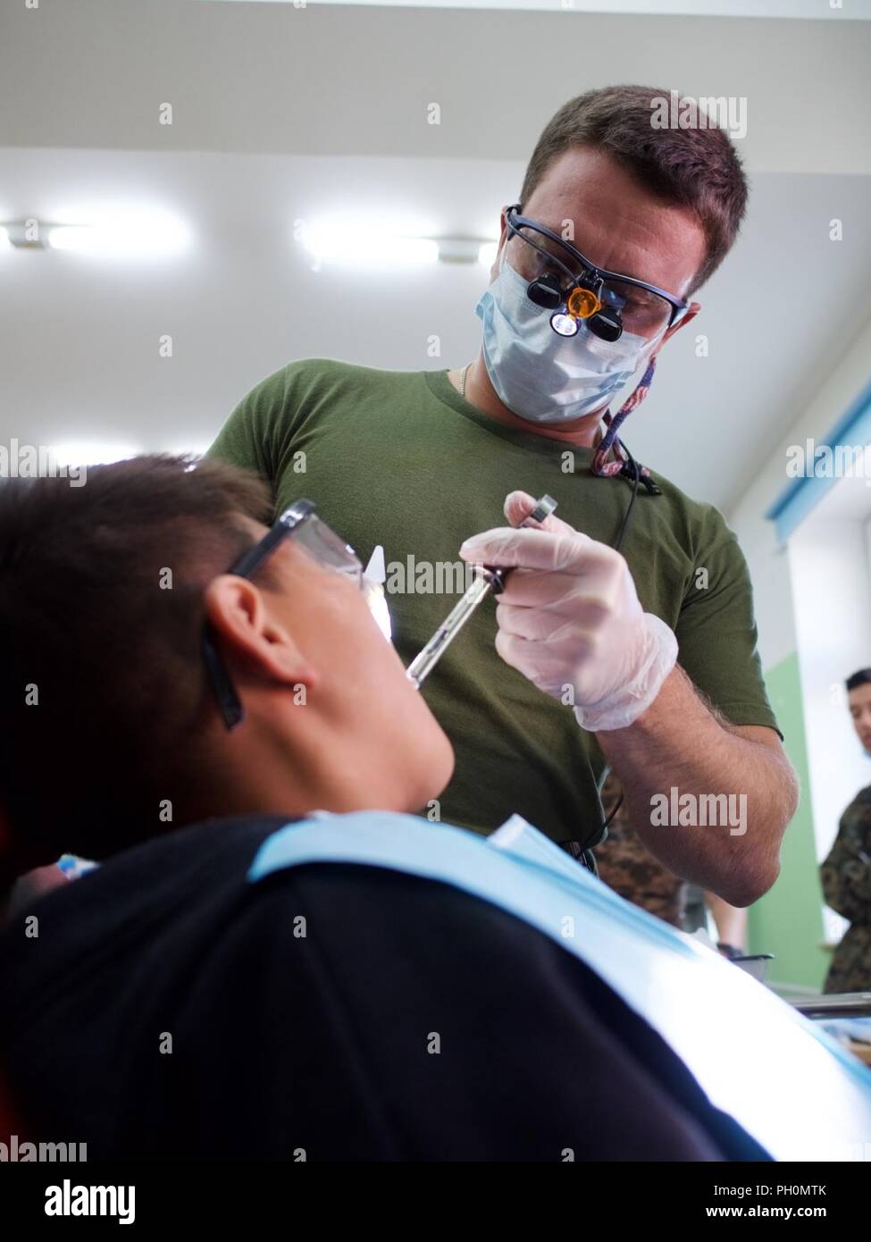 Stati Uniti Navy Lt. Ryan Davis, un dentista generale con 3° Battaglione dentale, amministra anestetico locale Giugno 18, 2018 a residente locale Erdenebileg durante la ricerca Khaan 2018 Servizi Sanitari Impegno di supporto presso la Scuola di 134, Ulaanbaatar, in Mongolia. Ricerca Khaan 2018 è un combinato (multinazionale) giunto (multi-service) esercizio di formazione intese a rafforzare le capacità degli Stati Uniti, mongola e altre nazioni partner internazionali in operazioni a sostegno della pace. Foto Stock