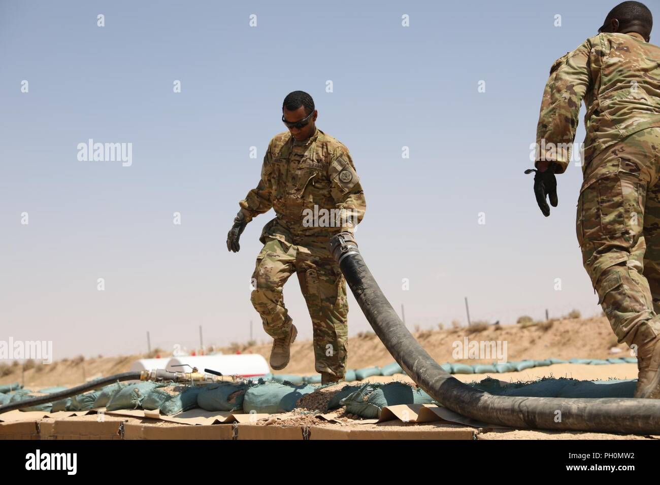 Stati Uniti I membri dell'esercito con il 3° reggimento di cavalleria, a lavorare in una area di immagazzinamento del combustibile in Al Qaim, Iraq, 15 giugno 2018. Ci sono 75 i partner della coalizione impegnata verso l'obiettivo di eliminare la minaccia rappresentata da ISIS in Iraq e Siria e hanno contribuito in vari modi per lo sforzo. Foto Stock