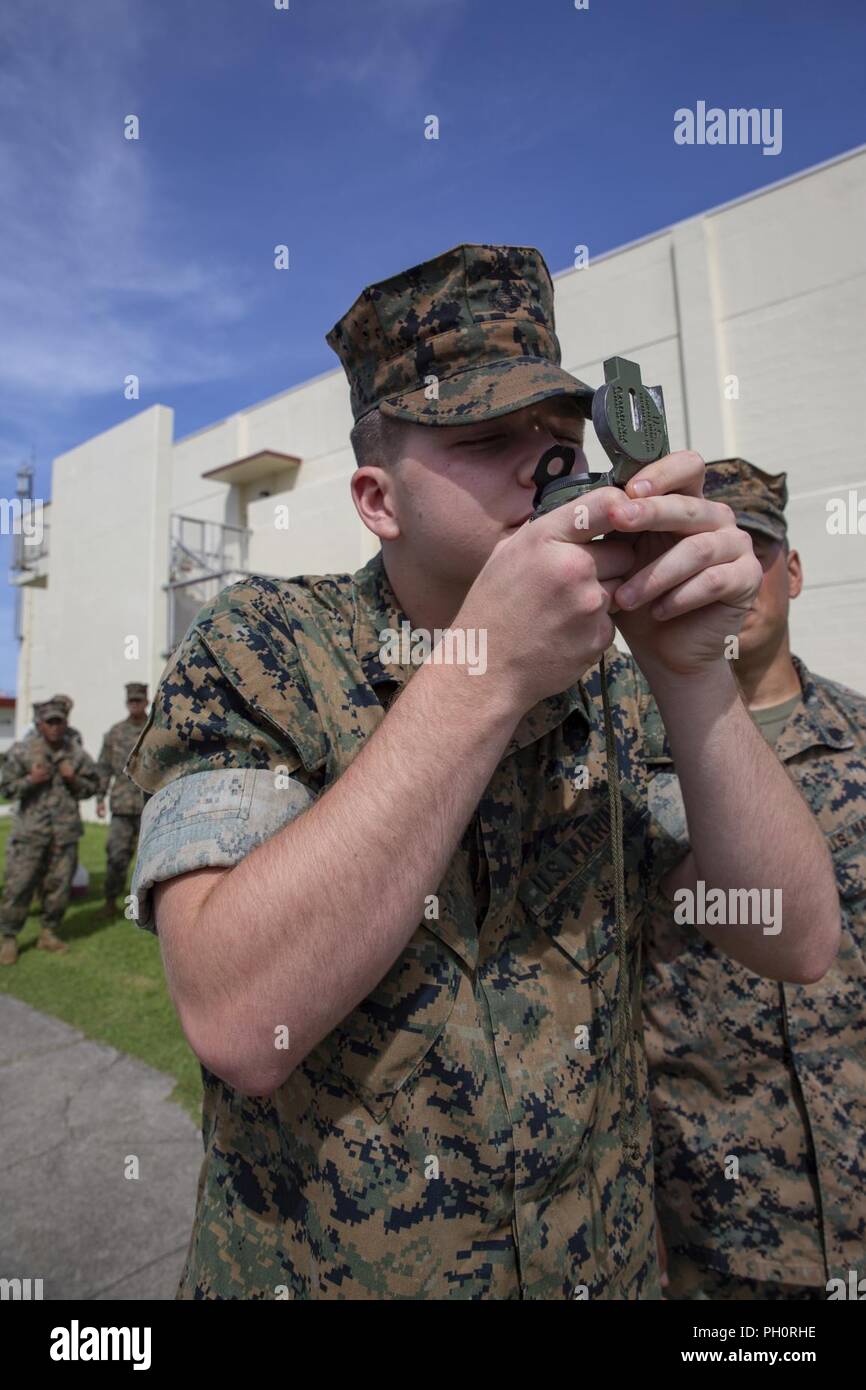 Pfc. Bailey Koger, un impiegato di alimentazione con sede reggimento, 3° Marine Logistics Group, pratiche utilizzando una bussola durante la Battaglia di test di abilità di Giugno 21, 2018 a Camp Kinser, Okinawa, in Giappone. Durante la BST, Marines sono testati su diverse competenze quali il funzionamento di una radio, applicando tourniquets e movimentazione di detenuti. Koger è un nativo di Nashville, Tennessee. Foto Stock