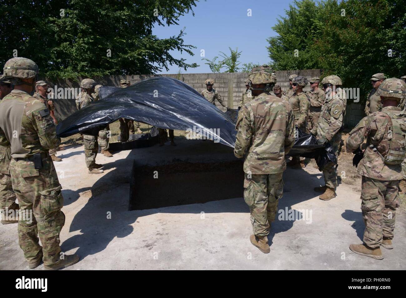 Stati Uniti Paracadutisti dell'esercito assegnato al Bravo Company, 54th ingegnere vigili del Battaglione, 173rd Brigata Aerea, posizionare il foglio impermeabile durante l'Aviosuperficie di luce di riparazione e cratere di formazione di riparazione con la elevata mobilità Engineer escavatore (HMEE) vicino a Trecenta , Rovigo, 20 giugno 2018. Il 173rd Brigata Aerea, con sede in Vicenza, Italia, è l'U.S. Esercito di risposta di emergenza forza in Europa, in grado di proiettare le forze per condurre la gamma completa delle operazioni militari su tutto il territorio degli Stati Uniti, europeo centrale e comandi Africa aree di responsabilità. Foto Stock