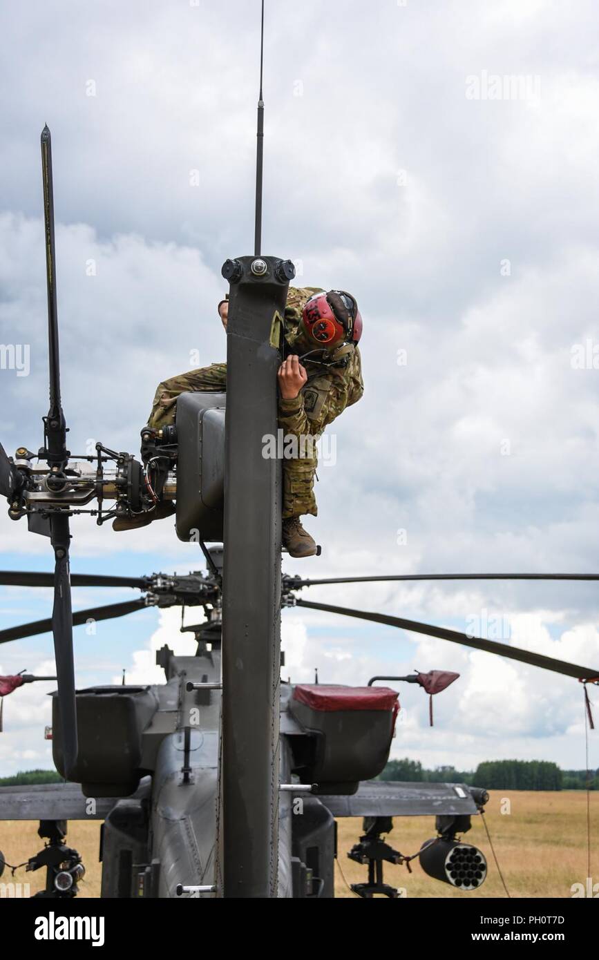 Sgt. Ryan Perea assegnato alla Task Force Viper° Battaglione, 3° Reggimento di aviazione, XII Combattere la Brigata Aerea effettuare manutenzione su AH-64 Apache elicottero durante lo sciopero di Saber 18 esercizi a Bemowo Piskie Area Formazione in Orzysz, Polonia, 14 giugno 2018. Foto Stock