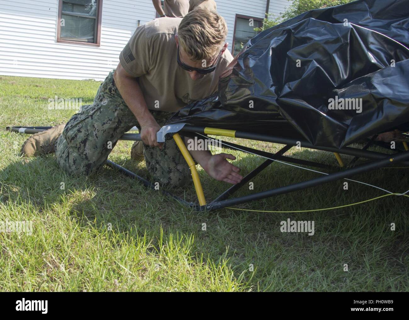 VIRGINIA BEACH, Va. (19 giugno 2018) Il tenente j.g. T.J. Hanzsche, assegnato per l'eliminazione degli ordigni esplosivi supporto Expeditionary Unit (EODESU) 2, consente di impostare una tenda durante un esercizio di mobilità (MOBEX) in preparazione per il disaster operazioni di risposta. Il MOBEX, tenutasi al giunto di base Expeditionary poco Creek-Fort storia, è volto a formare e valutare le abilità di mobilità per attività future. EODGRU 2 ha la sua sede centrale a JEBLCFS e supervisiona le immersioni Mobile e unità di soccorso (MDSU) 2 e tutti costa orientale basato EOD unità mobili. Foto Stock