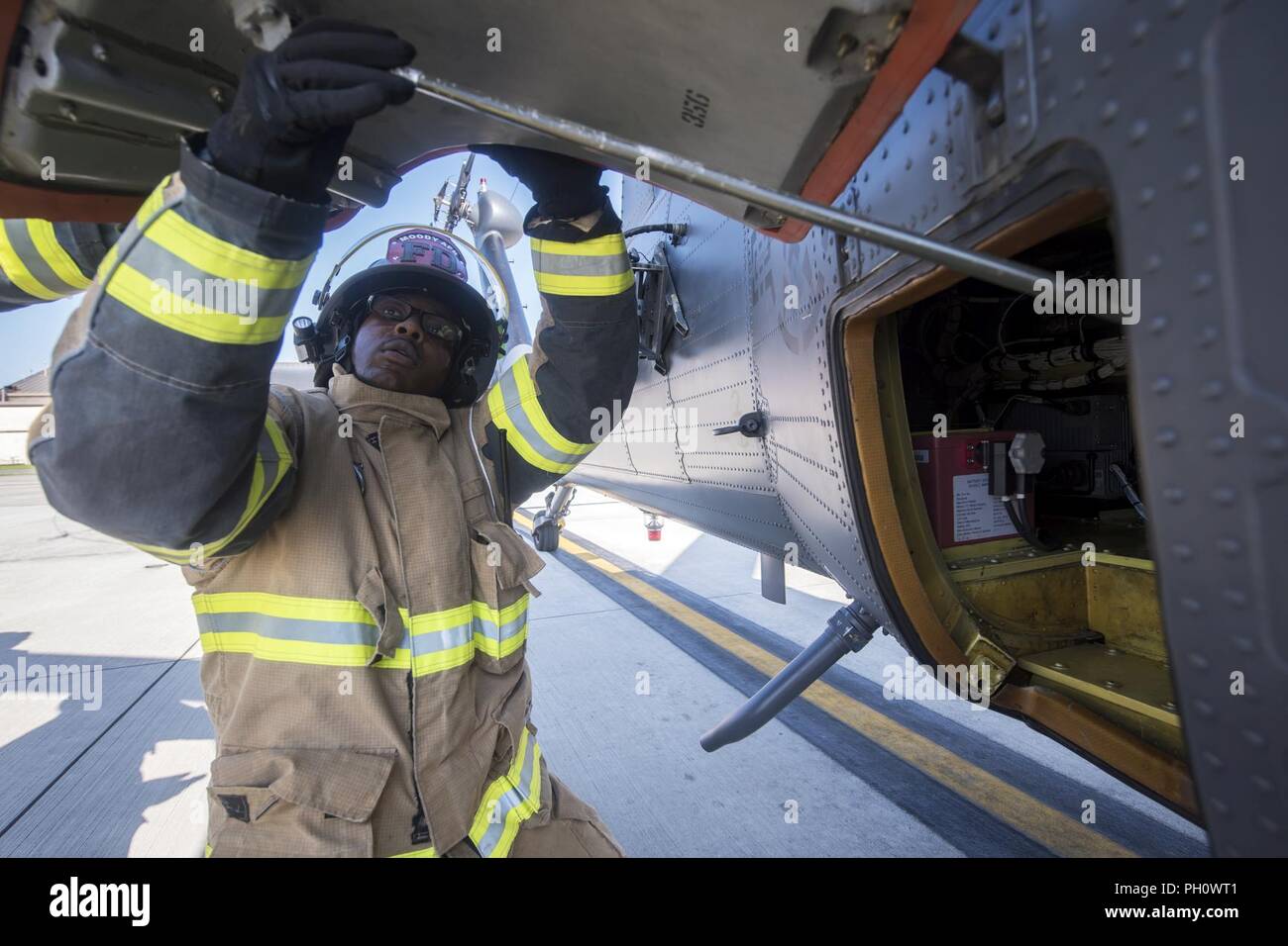 Il personale Sgt. Tyler McFarland, 23d' ingegnere civile Squadron (CES) pompiere, tira il portello alla batteria di un HH-60G Pave Hawk, durante un salvataggio simulato lo scenario di addestramento, Giugno 19, 2018 a Moody Air Force Base, Ga. 23d CES vigili del fuoco ha condotto la formazione per valutare la loro conoscenza generale e preparazione di come spegnere correttamente e il salvataggio di membri dell'equipaggio provenienti da un HH-60. Foto Stock