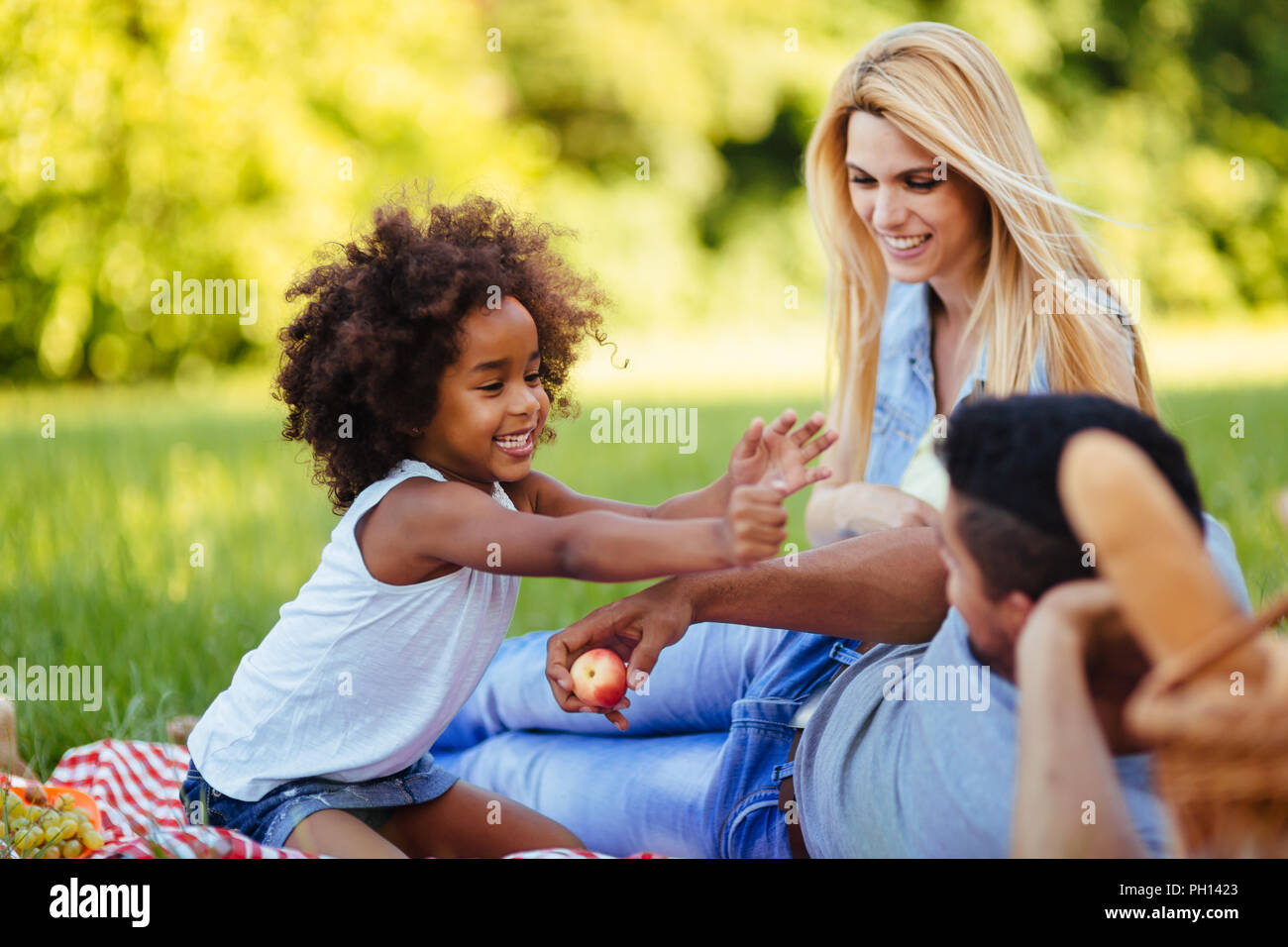 Immagine della coppia adorabile con la loro figlia avente picnic Foto Stock