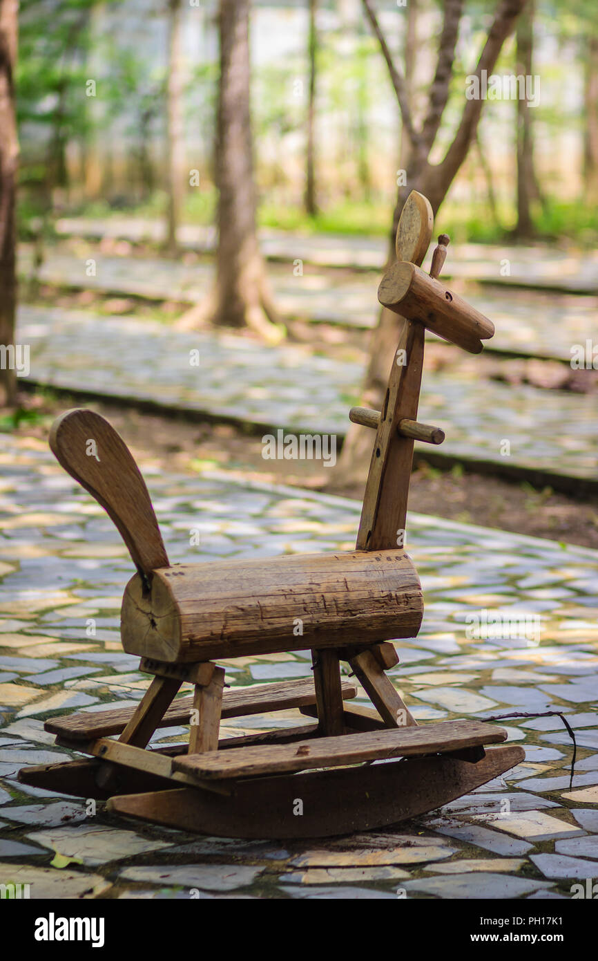 Antiquariato in legno marrone a dondolo Giocattolo del cane nel parco pubblico. Foto Stock