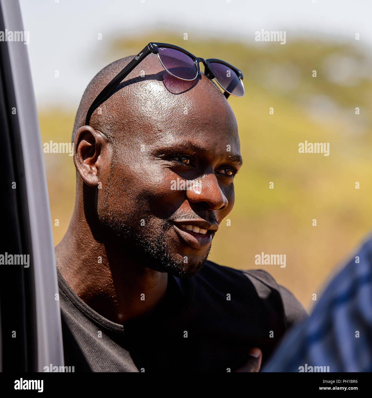 Strada di LAMPOUL, SENEGAL - Apr 23, 2017: Non identificato uomo senegalesi  in camicia nera con occhiali da sole sorride. Ancora molte persone in  Senegal vivono in pover Foto stock - Alamy