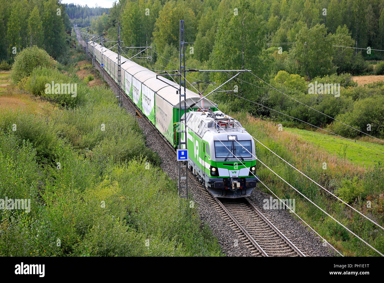 ORIVESI, Finlandia - 27 agosto 2018: VR treno merci viaggia attraverso il verde nella tarda estate del paesaggio in Finlandia centrale, vista in elevazione da un ponte. Foto Stock