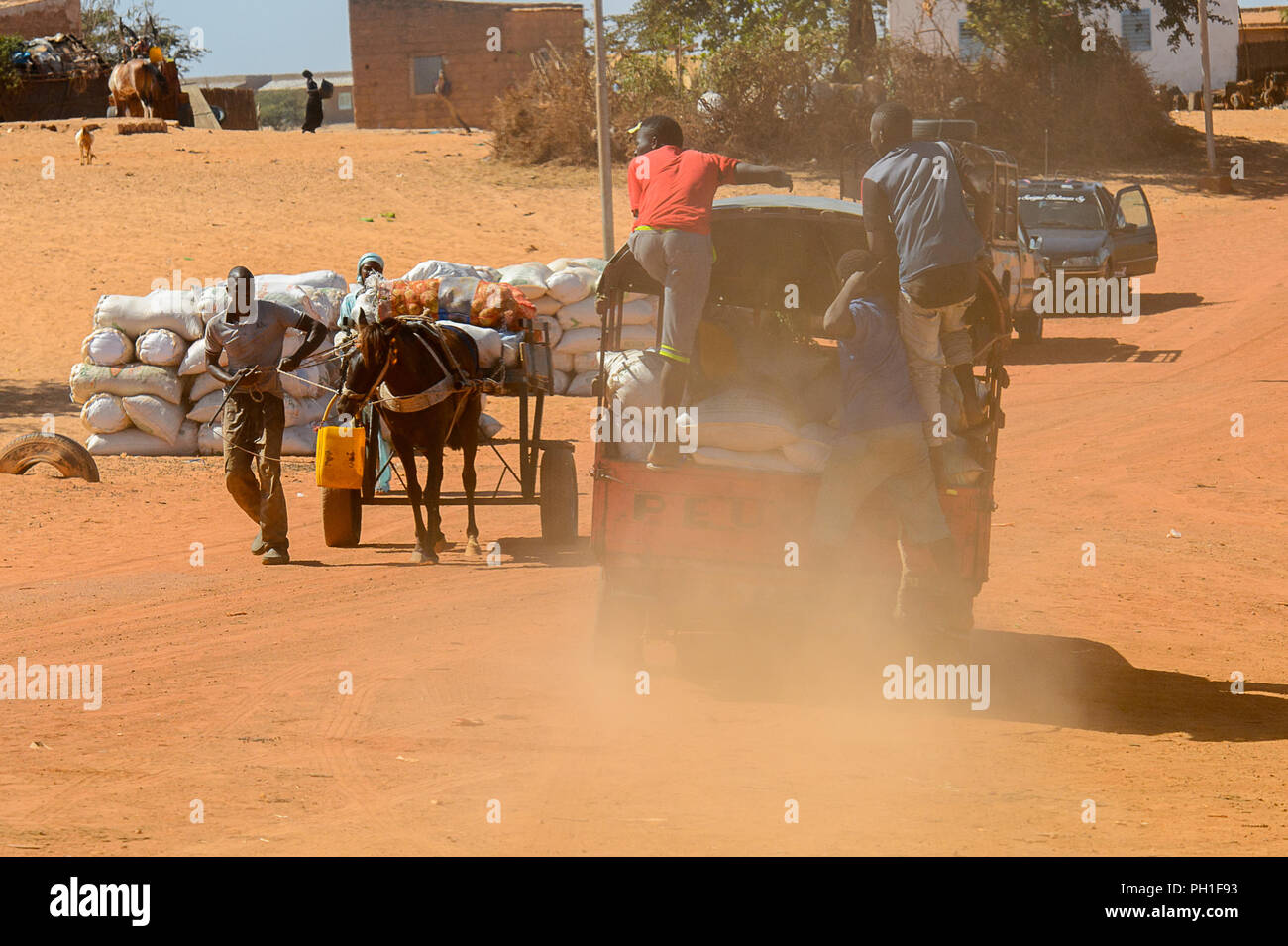 Deserto LAMPOUL village, SENEGAL - Apr 23, 2017: Non identificato gli uomini senegalesi giro in auto piena di sacchetti in un villaggio vicino al deserto Lampoul Foto Stock