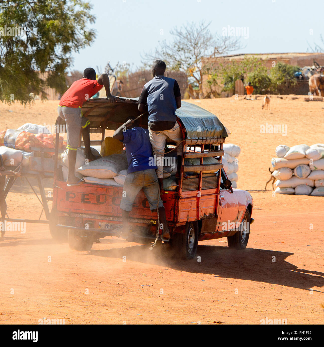 Deserto LAMPOUL village, SENEGAL - Apr 23, 2017: Non identificato gli uomini senegalesi giro in auto piena di sacchetti in un villaggio vicino al deserto Lampoul Foto Stock
