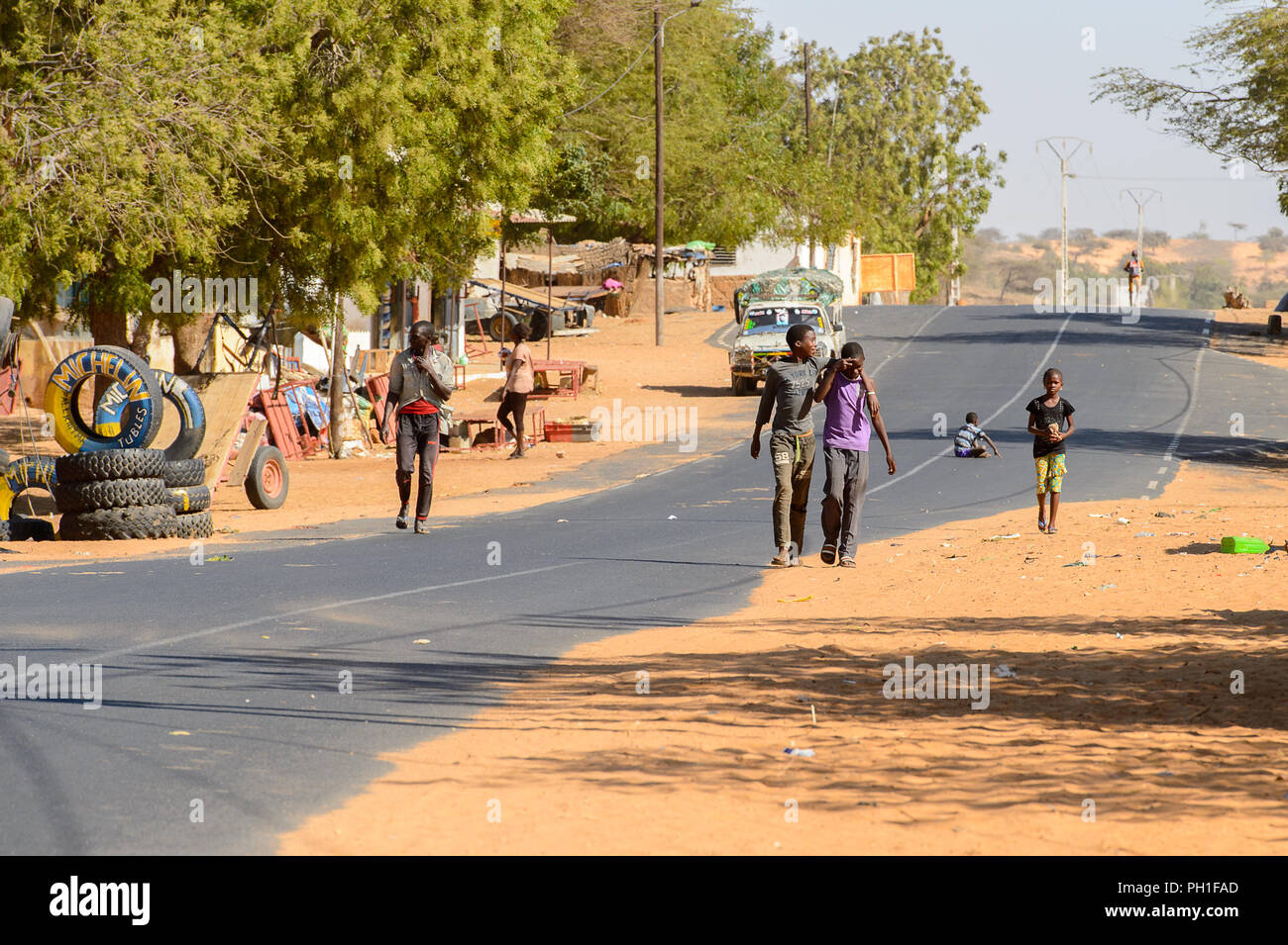 Deserto LAMPOUL village, SENEGAL - Apr 23, 2017: Unidentified senegalesi a piedi lungo la strada in un villaggio vicino al deserto Lampoul Foto Stock