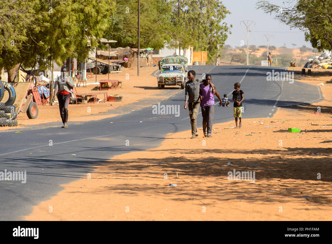 Deserto LAMPOUL village, SENEGAL - Apr 23, 2017: Unidentified senegalesi a piedi lungo la strada in un villaggio vicino al deserto Lampoul Foto Stock