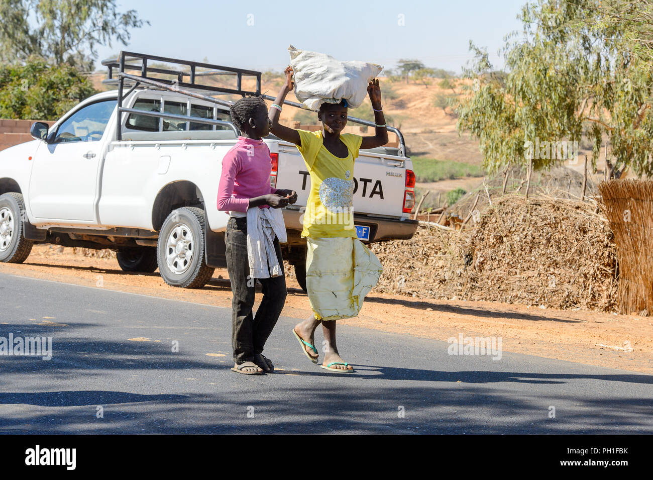 Deserto LAMPOUL village, SENEGAL - Apr 23, 2017: Non identificato donna senegalese porta un sacco sul suo capo in un villaggio vicino al deserto Lampoul Foto Stock