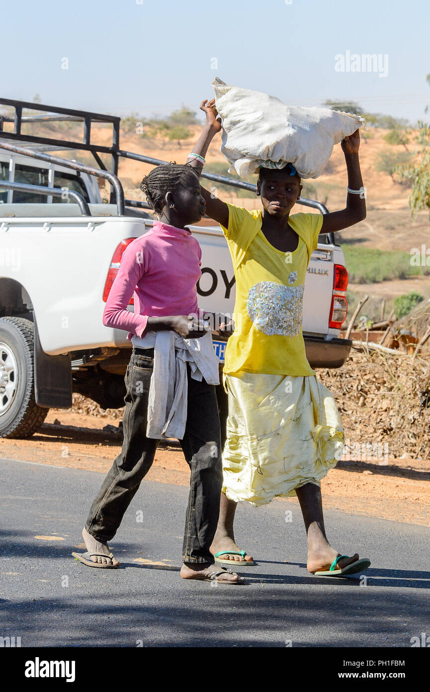 Deserto LAMPOUL village, SENEGAL - Apr 23, 2017: Non identificato donna senegalese porta un sacco sul suo capo in un villaggio vicino al deserto Lampoul Foto Stock