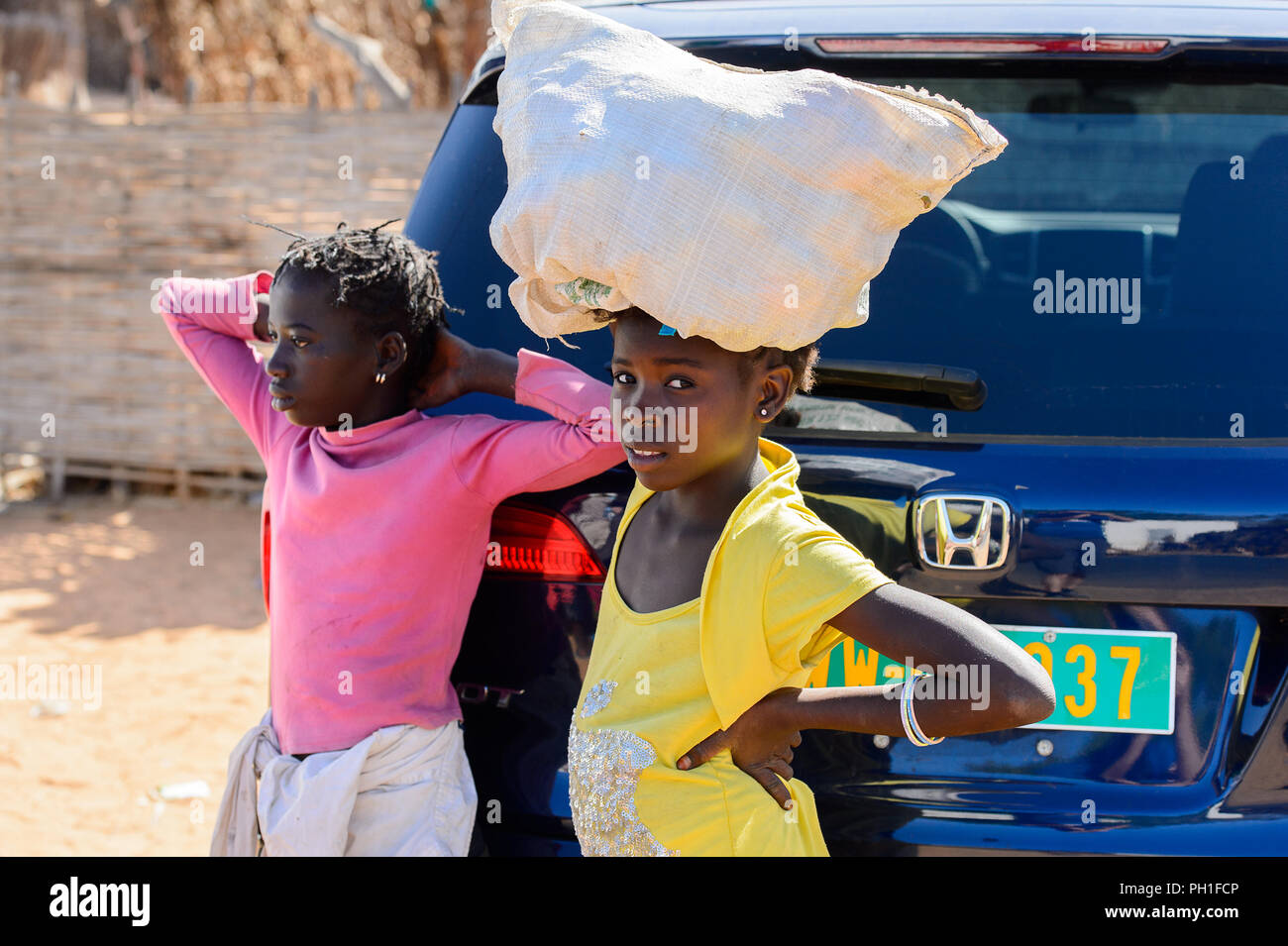 Deserto LAMPOUL village, SENEGAL - Apr 23, 2017: Non identificato donna senegalese porta un sacco sul suo capo in un villaggio vicino al deserto Lampoul Foto Stock