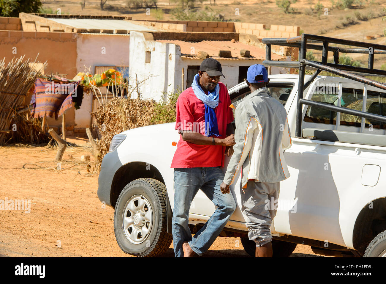 Deserto LAMPOUL village, SENEGAL - Apr 23, 2017: Senegalesi non identificato due uomini sostare vicino la vettura in un villaggio vicino al deserto Lampoul Foto Stock