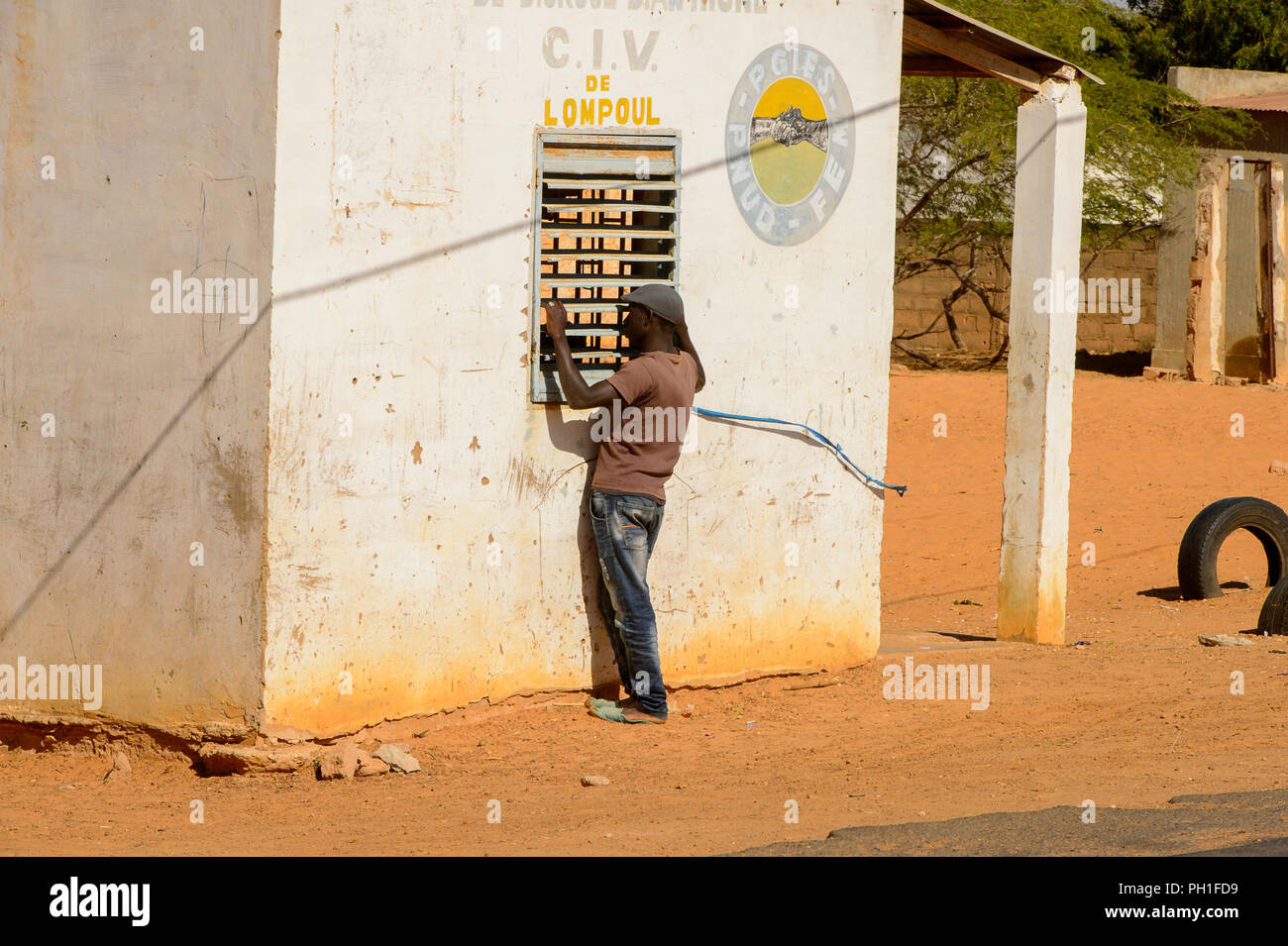 Deserto LAMPOUL village, SENEGAL - Apr 23, 2017: Non identificato uomo senegalese sorge vicino alla finestra in un villaggio vicino al deserto Lampoul Foto Stock
