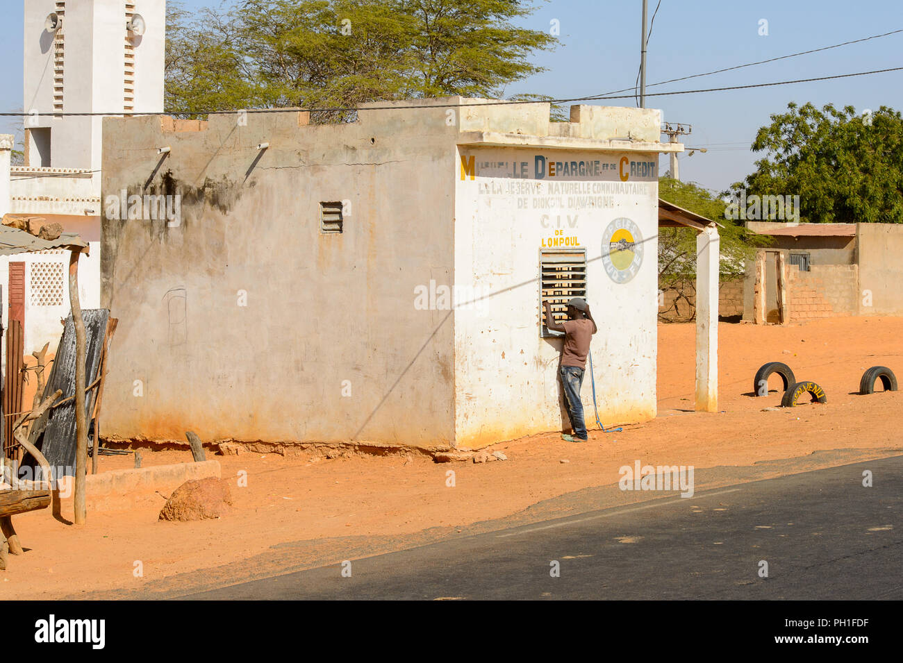Deserto LAMPOUL village, SENEGAL - Apr 23, 2017: Non identificato uomo senegalese sorge vicino alla finestra in un villaggio vicino al deserto Lampoul Foto Stock
