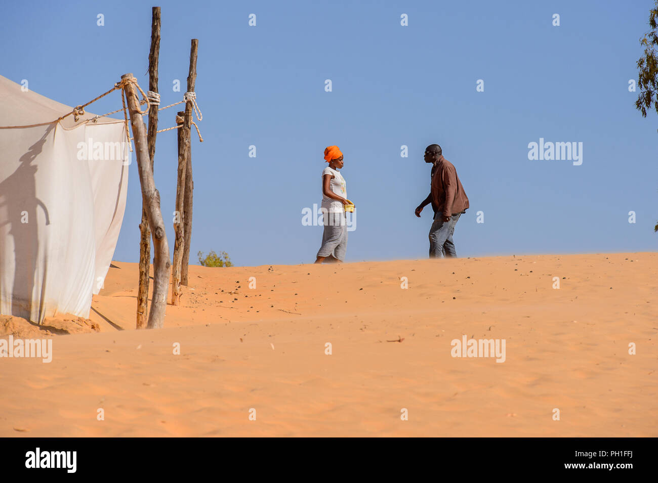 Deserto LAMPOUL, SENEGAL - Apr 23, 2017: Non identificato uomo senegalese e la donna parlare di qualcosa in un deserto Lampoul, bellissimo paesaggio luogo Foto Stock