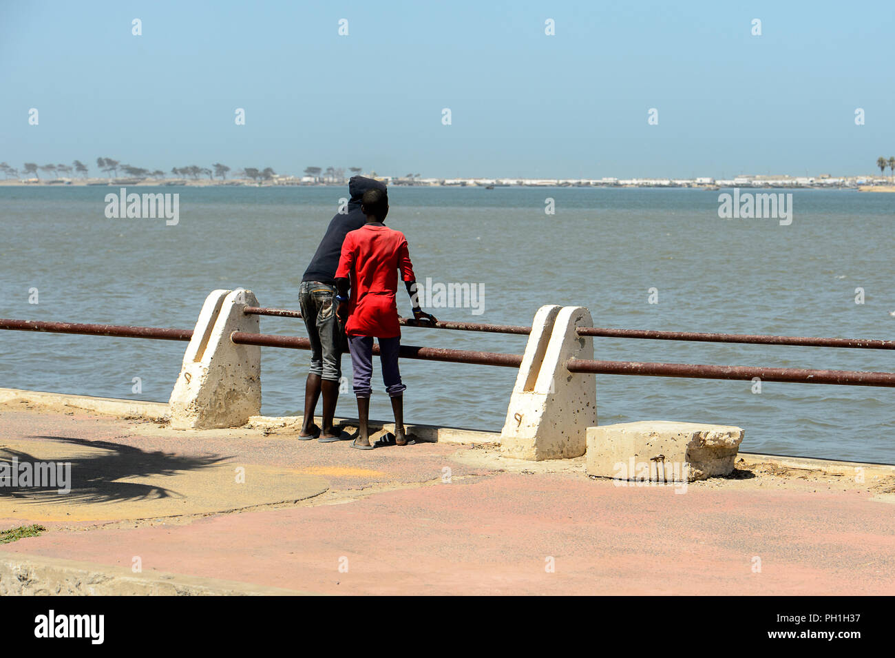 SAINT LOUIS, SENEGAL - Apr 25, 2017: Senegalesi non identificato due ragazzi stand sul molo e guarda l'oceano in Saint Louis, uno dei più grandi citie Foto Stock