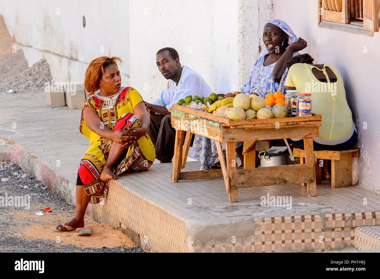 SAINT LOUIS, SENEGAL - Apr 24, 2017: Unidentified senegalesi sedersi per terra e vendere i frutti di fianco alla strada a Saint Louis, uno dei bigge Foto Stock