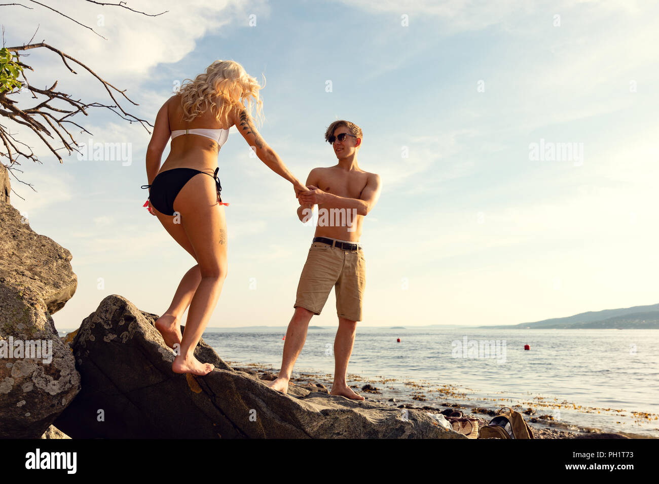 Matura in amore tenendo le mani in spiaggia in estate Foto Stock