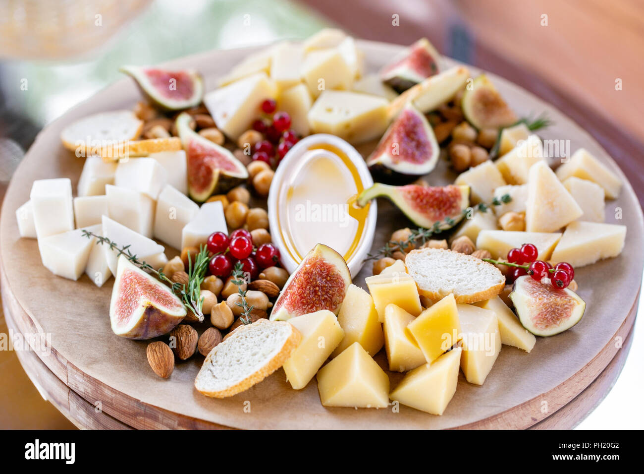 Il Piatto Di Formaggi Una Deliziosa Miscela Di Formaggio Con Crostoni Di Pane Baguette Ribes Rosso Dolci Fichi Mandorle Miele Sul Tavolo Di Legno Degustazione Piatto Su Una Lastra Di Legno Cibo