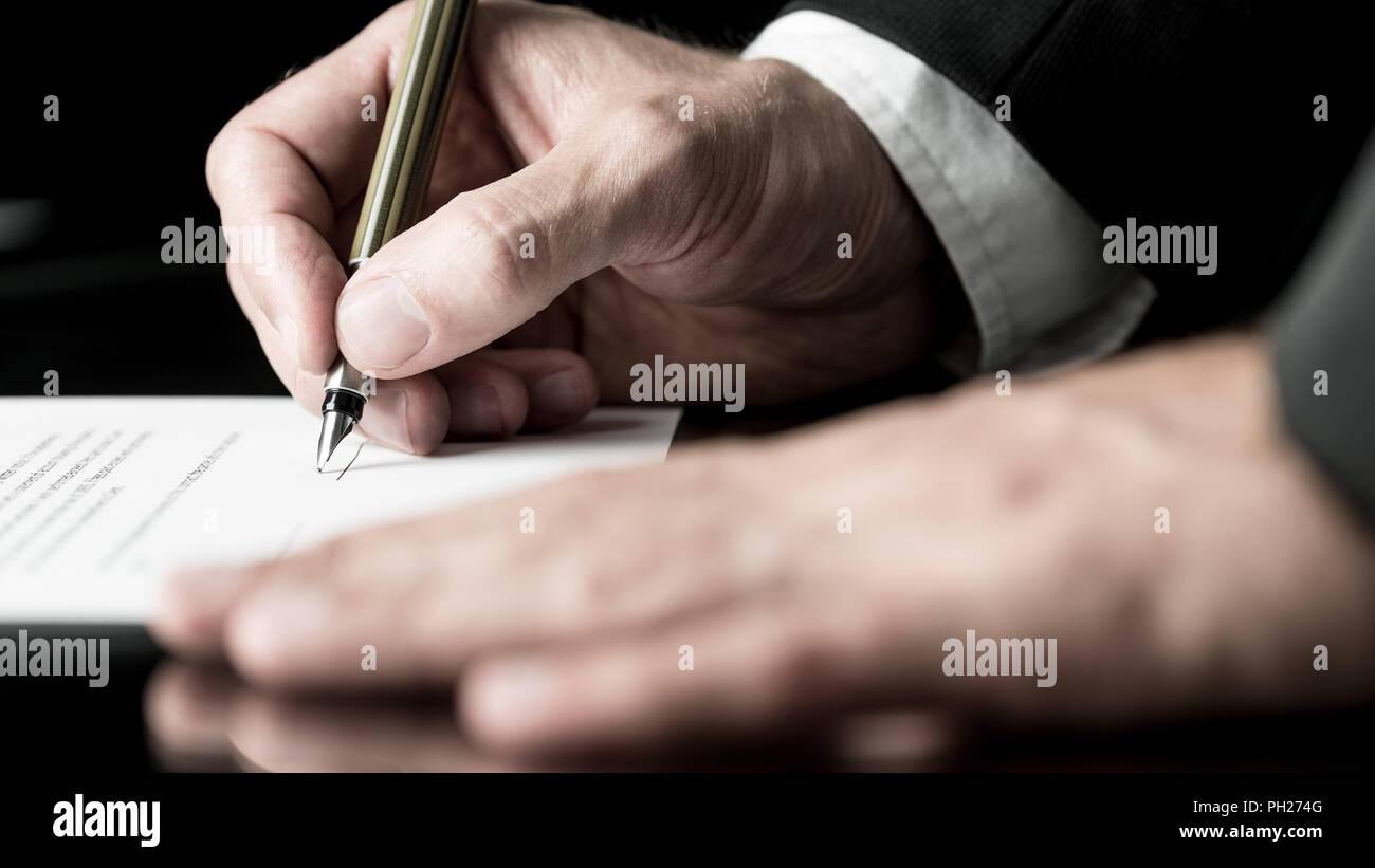 Dissaturato immagine delle mani di un uomo d affari con la firma di un contratto con una penna stilografica. Foto Stock