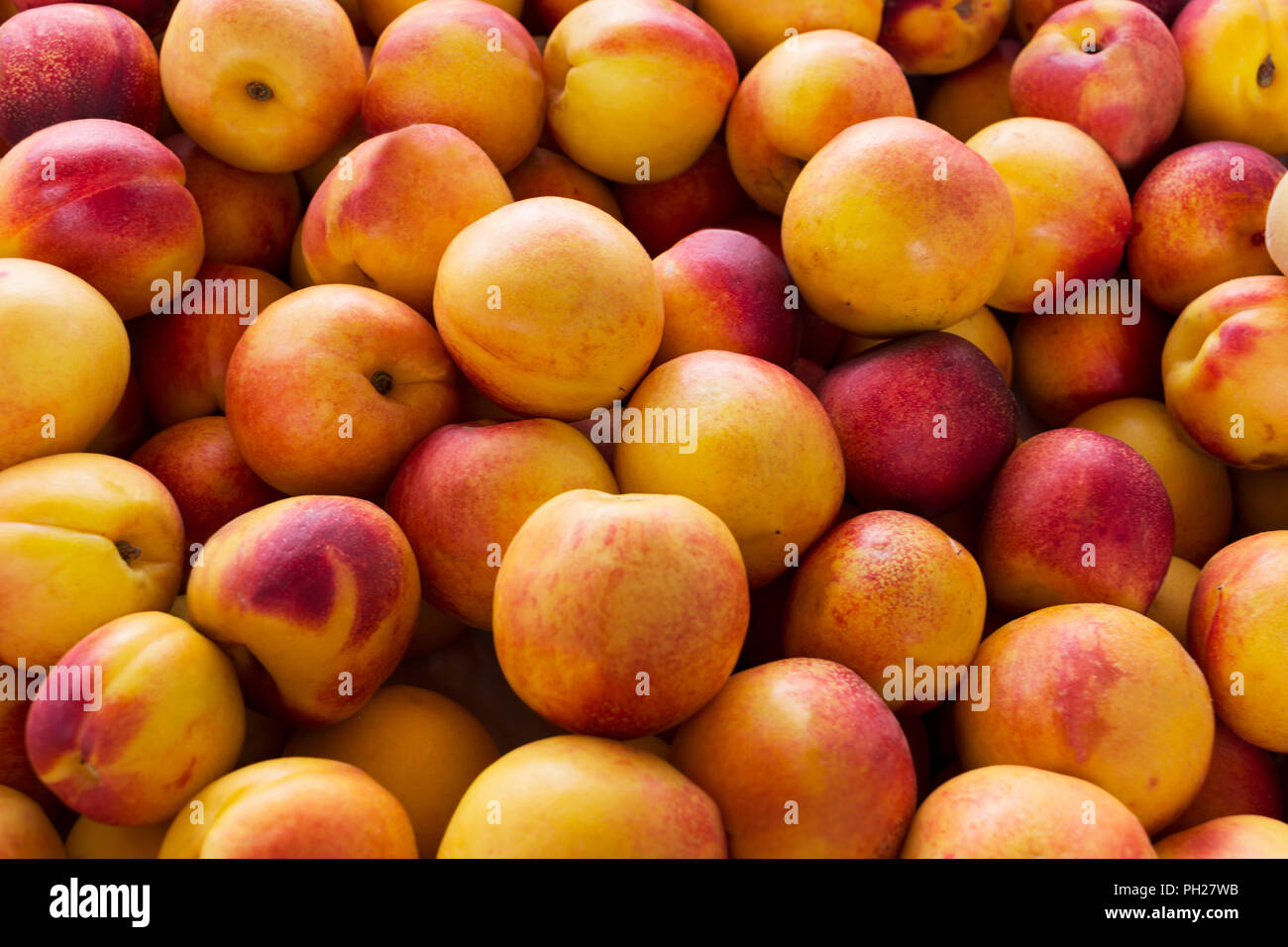 Giallo fresco pesche noci background come abbondanza simbolo del raccolto. Cibo vegetariano concetto con frutti maturi Foto Stock