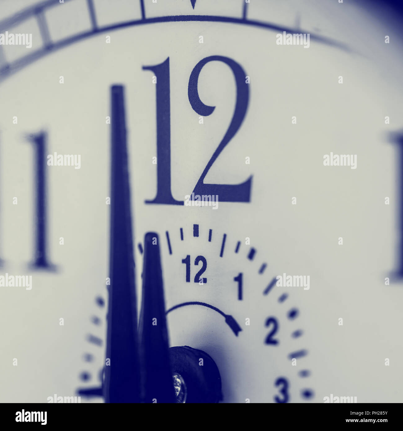 Orologio circa di sciopero a mezzanotte o mezzogiorno , closeup effetto retrò vista con la messa a fuoco a due cifre del numero 12 e shallow dof, eventualmente concep Foto Stock